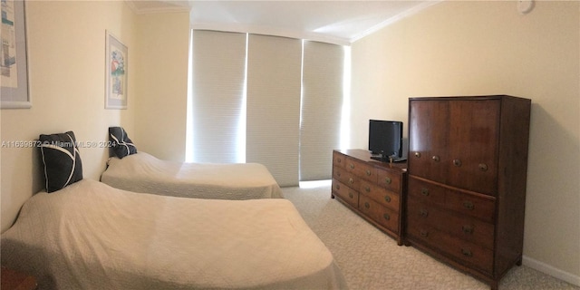 bedroom featuring ornamental molding and light carpet