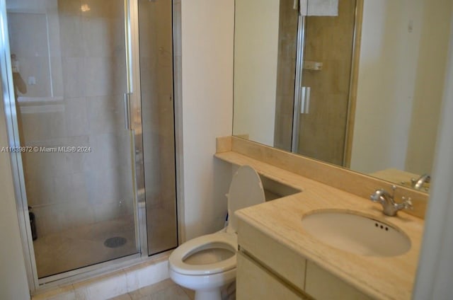 bathroom with vanity, tile patterned floors, an enclosed shower, and toilet