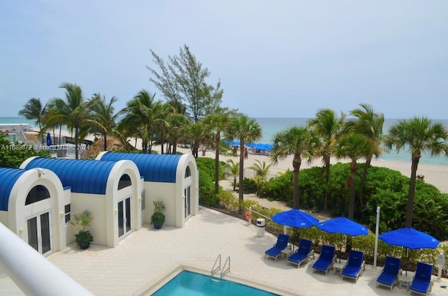 view of swimming pool featuring a water view and a patio area