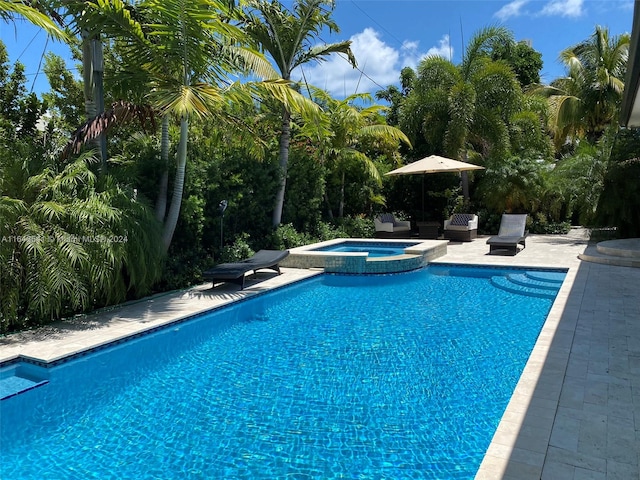 view of pool with an in ground hot tub and a patio area