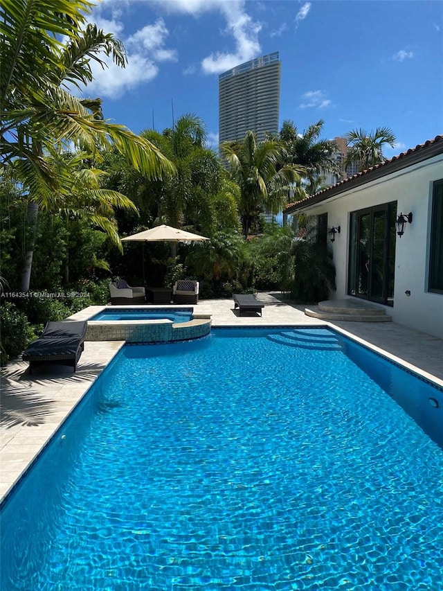 view of swimming pool with an in ground hot tub and a patio area