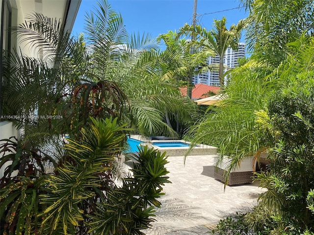 view of pool featuring an in ground hot tub and a patio