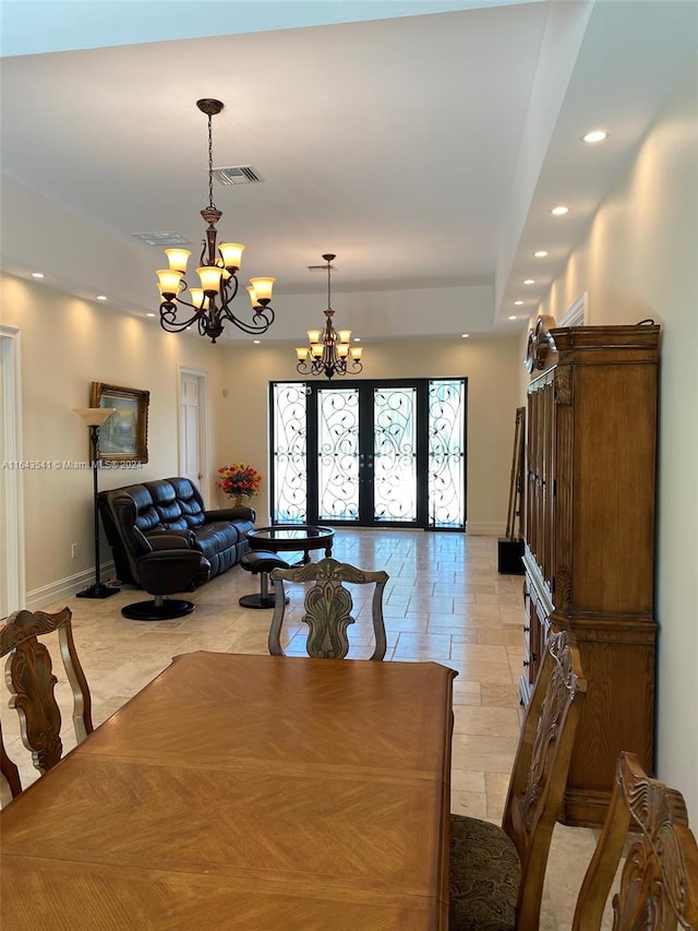 dining room featuring a raised ceiling, a notable chandelier, light tile patterned floors, and french doors