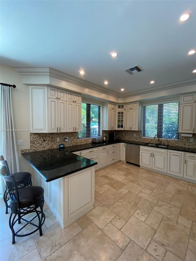 kitchen with decorative backsplash, sink, ornamental molding, and stainless steel dishwasher