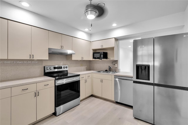 kitchen with ceiling fan, tasteful backsplash, light hardwood / wood-style floors, sink, and stainless steel appliances