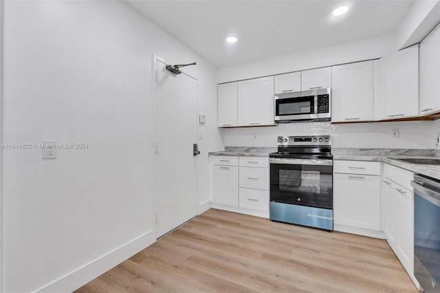 kitchen featuring white cabinets, light wood-type flooring, sink, and appliances with stainless steel finishes