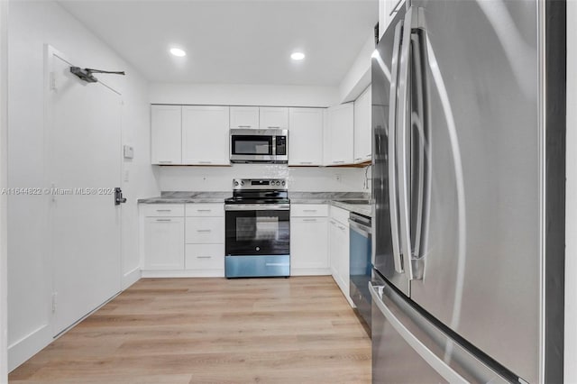 kitchen featuring stainless steel appliances, light hardwood / wood-style floors, white cabinets, and light stone counters