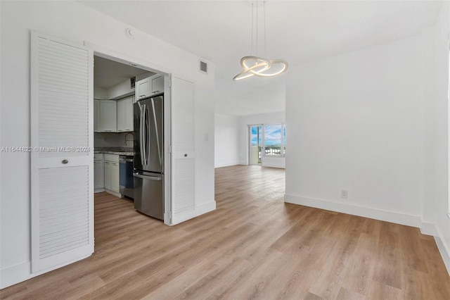 unfurnished dining area featuring light wood-type flooring and sink