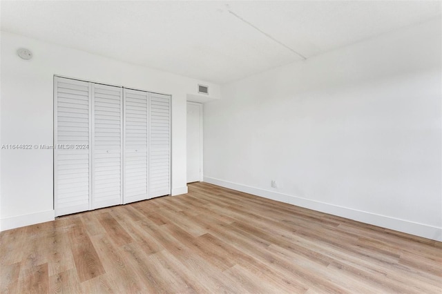 unfurnished bedroom featuring light hardwood / wood-style floors and a closet