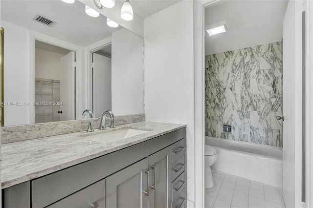 full bathroom featuring toilet, tiled shower / bath, vanity, and tile patterned floors