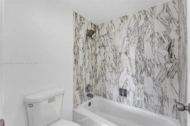 bathroom featuring tiled shower / bath and toilet