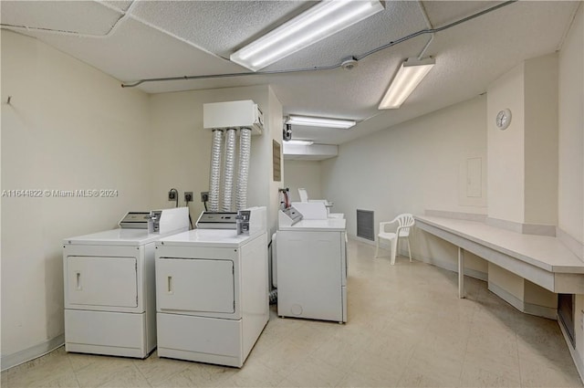 clothes washing area featuring light tile patterned floors and washing machine and clothes dryer