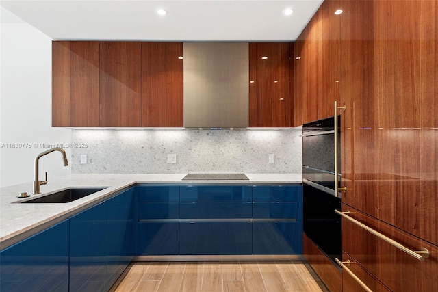 kitchen with decorative backsplash, black electric stovetop, light stone counters, and sink