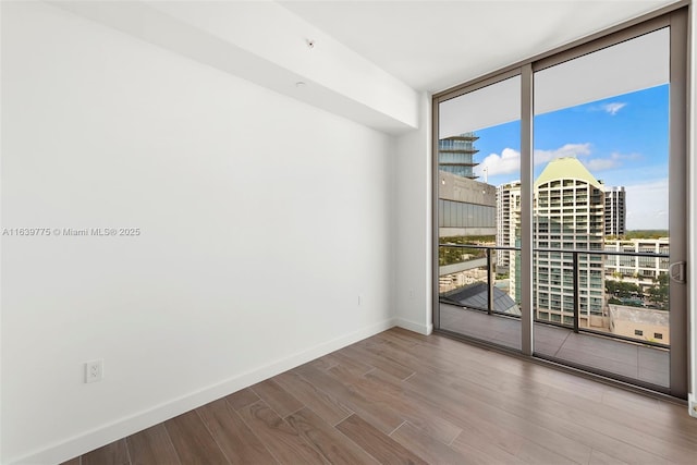 spare room featuring hardwood / wood-style flooring and floor to ceiling windows