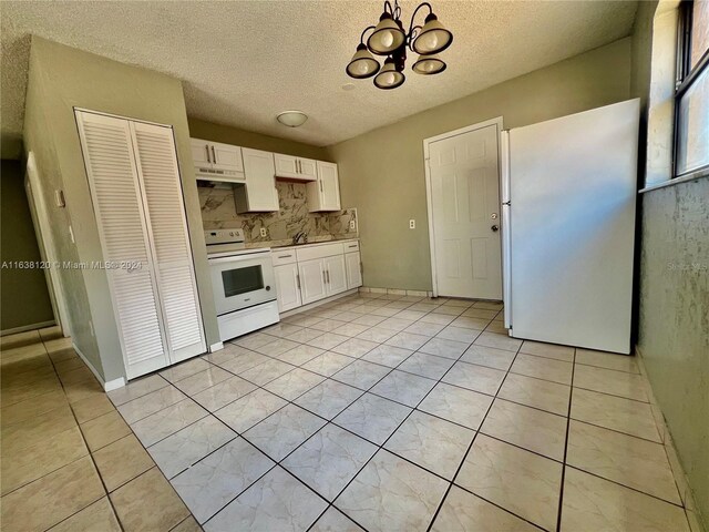 kitchen with white cabinetry, a chandelier, tasteful backsplash, light tile patterned floors, and white appliances