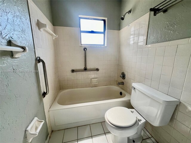 bathroom featuring tile patterned flooring, tile walls, toilet, and tiled shower / bath