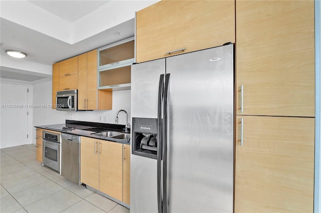 kitchen featuring appliances with stainless steel finishes, light tile patterned floors, and sink