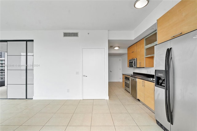 kitchen with stainless steel appliances and light tile patterned floors