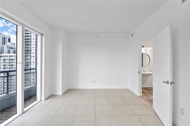 empty room featuring light tile patterned floors and sink