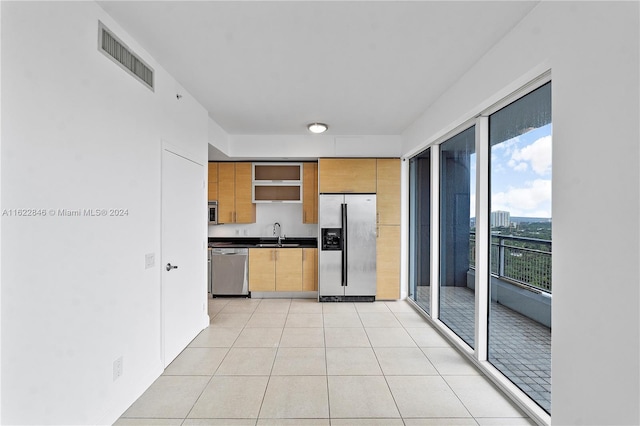 kitchen featuring light tile patterned floors, stainless steel appliances, and sink