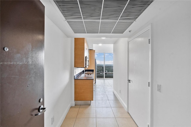 hallway featuring light tile patterned floors and expansive windows