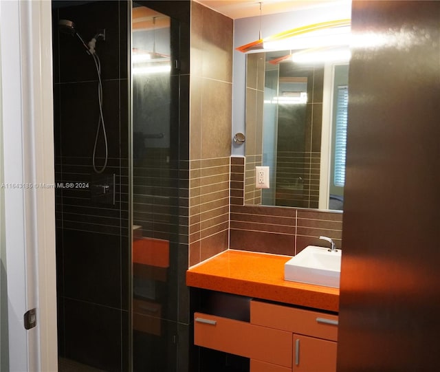 bathroom with decorative backsplash, a tile shower, and vanity