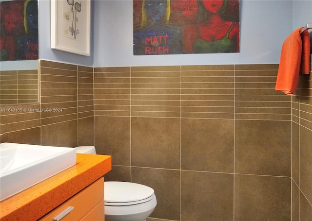 bathroom featuring tile walls, toilet, and vanity