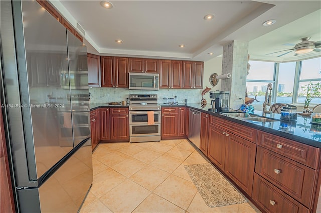 kitchen featuring appliances with stainless steel finishes, ceiling fan, light tile patterned floors, decorative columns, and decorative backsplash