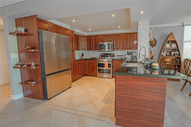 kitchen with ornate columns, decorative backsplash, kitchen peninsula, sink, and appliances with stainless steel finishes