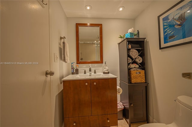 bathroom featuring walk in shower, vanity, and toilet