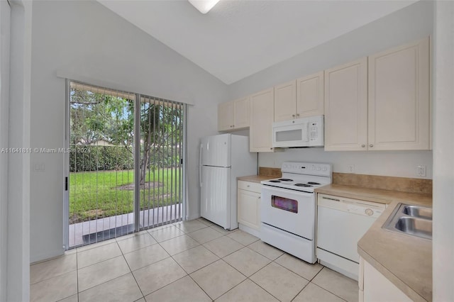 kitchen with sink, high vaulted ceiling, white appliances, light tile patterned floors, and white cabinets