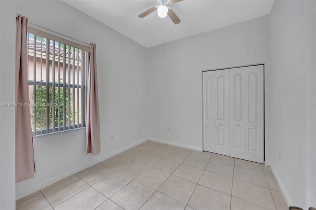 empty room with light tile patterned floors and ceiling fan