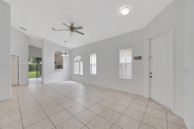 spare room with ceiling fan with notable chandelier and light tile patterned flooring