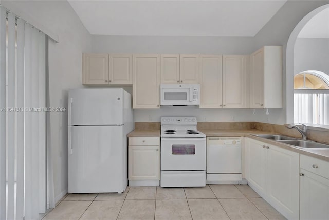 kitchen featuring sink, white appliances, and light tile patterned flooring