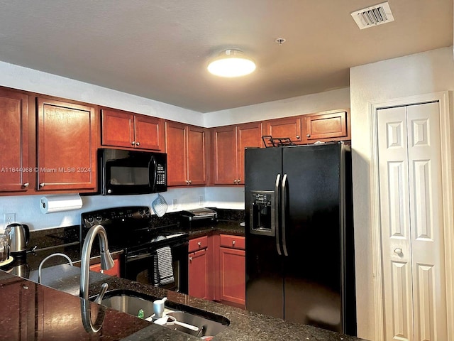 kitchen with black appliances and dark stone countertops