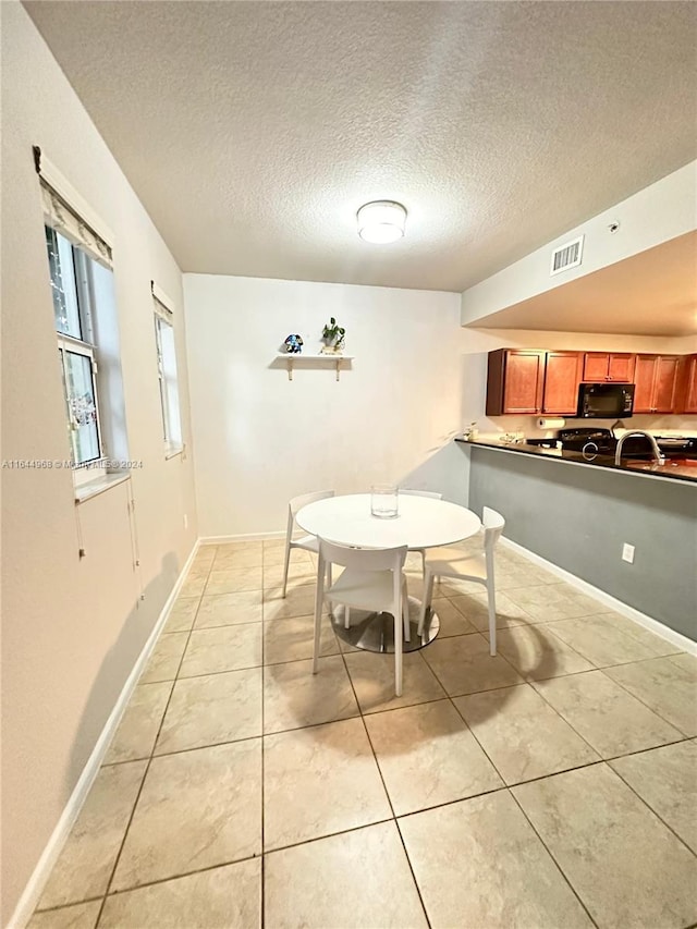 tiled dining room featuring a textured ceiling