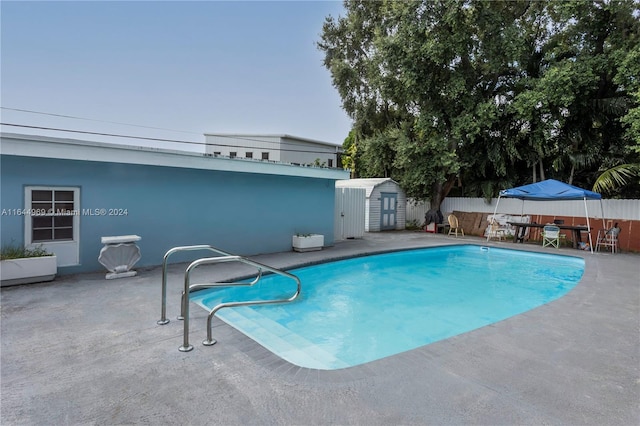 view of swimming pool featuring a patio and an outdoor structure