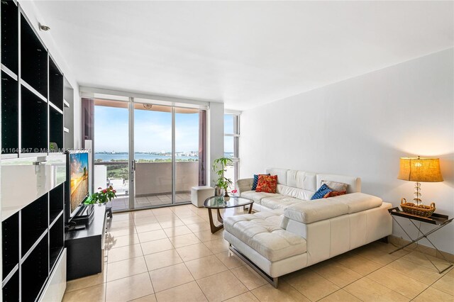 tiled living room featuring expansive windows and a water view