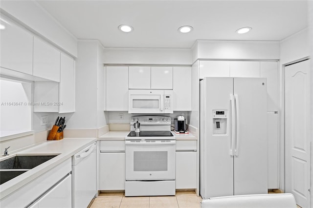 kitchen featuring white appliances, sink, light tile patterned floors, and white cabinets