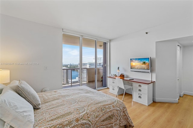 bedroom featuring a wall of windows, access to exterior, and light hardwood / wood-style floors