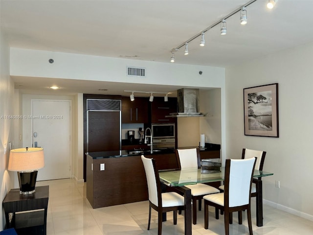 dining area featuring sink, light tile patterned flooring, and track lighting