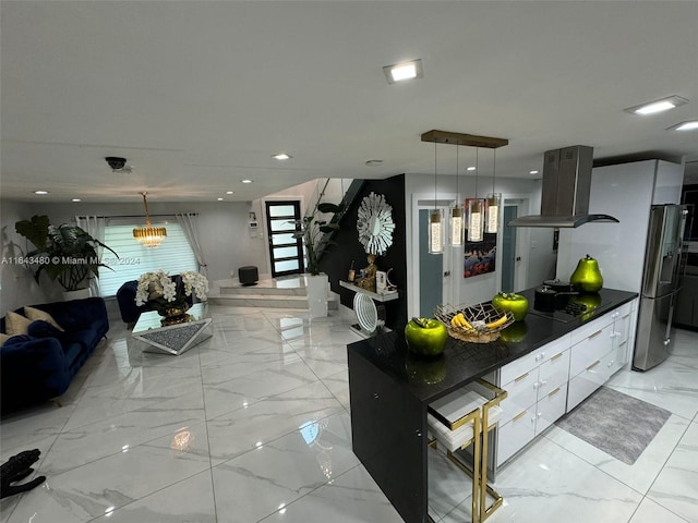 kitchen featuring island range hood, black electric cooktop, stainless steel fridge with ice dispenser, decorative light fixtures, and white cabinets