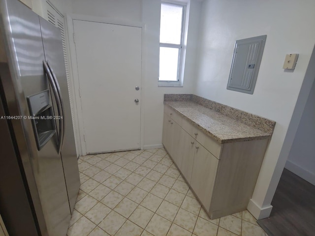 kitchen featuring stainless steel fridge with ice dispenser, electric panel, and light tile patterned floors