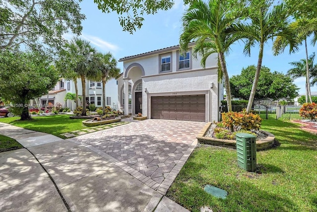 mediterranean / spanish house featuring a garage and a front yard