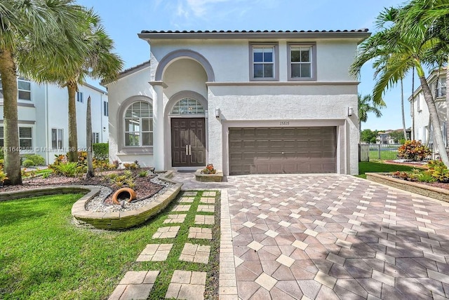 mediterranean / spanish-style house featuring a garage and a front yard