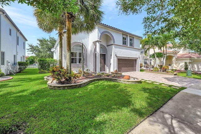 mediterranean / spanish-style house featuring a garage and a front lawn