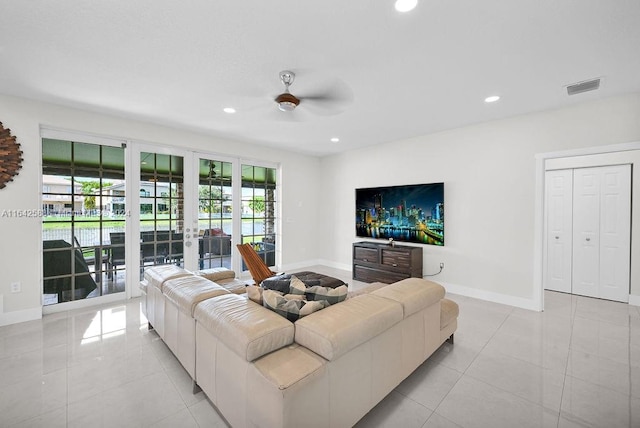 living room featuring ceiling fan, light tile patterned floors, and french doors