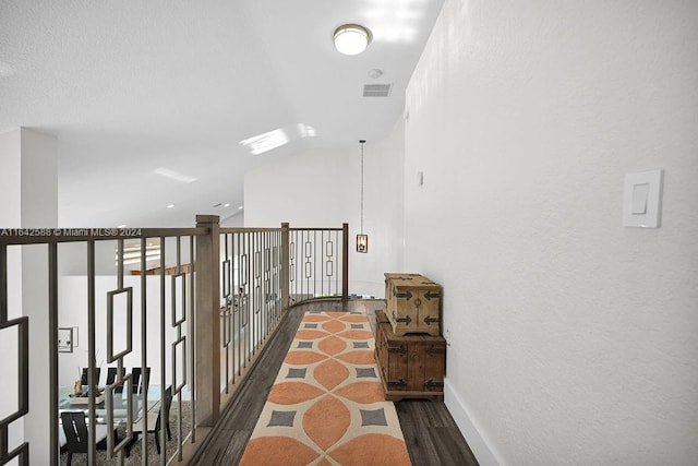 hallway with dark wood-type flooring and lofted ceiling