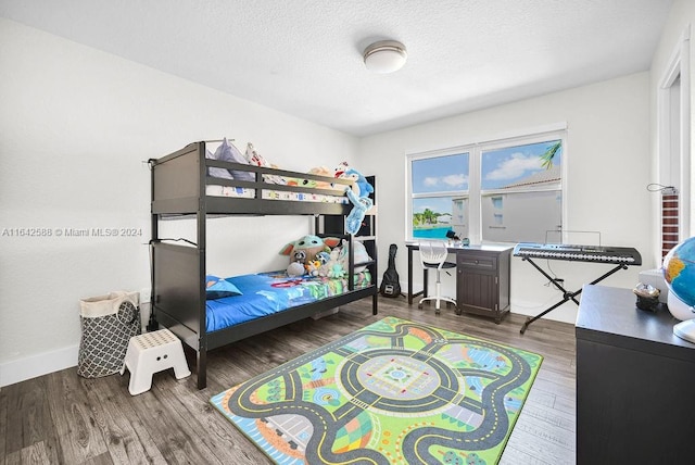 bedroom with dark wood-type flooring and a textured ceiling