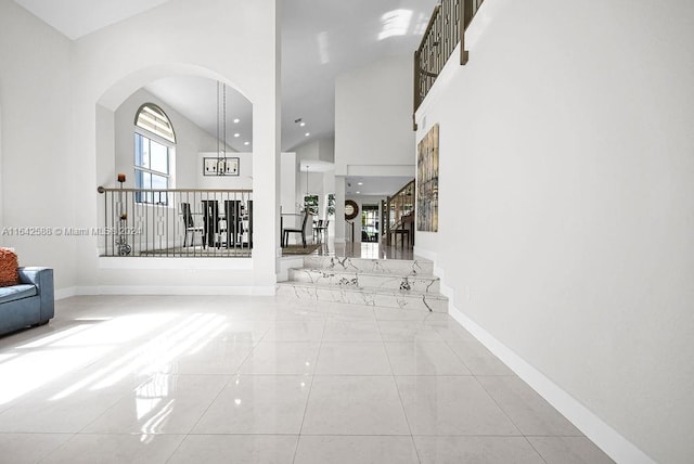 hallway with light tile patterned flooring and a chandelier